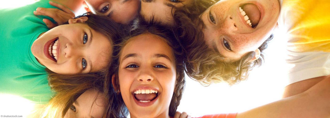 im Kreis liegende lachende Kinder