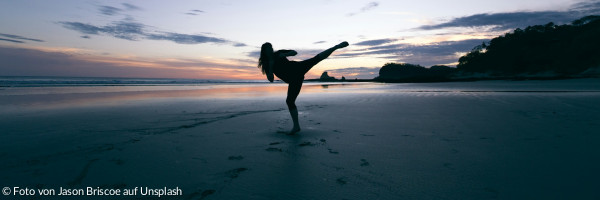 Silhouette einer Person, die in der Luft tritt