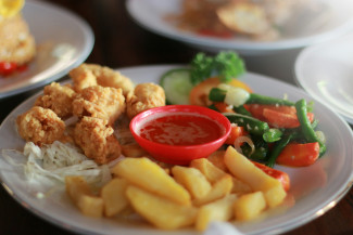 gebratenes Hähnchen und Pommes frites auf weißem Keramikteller